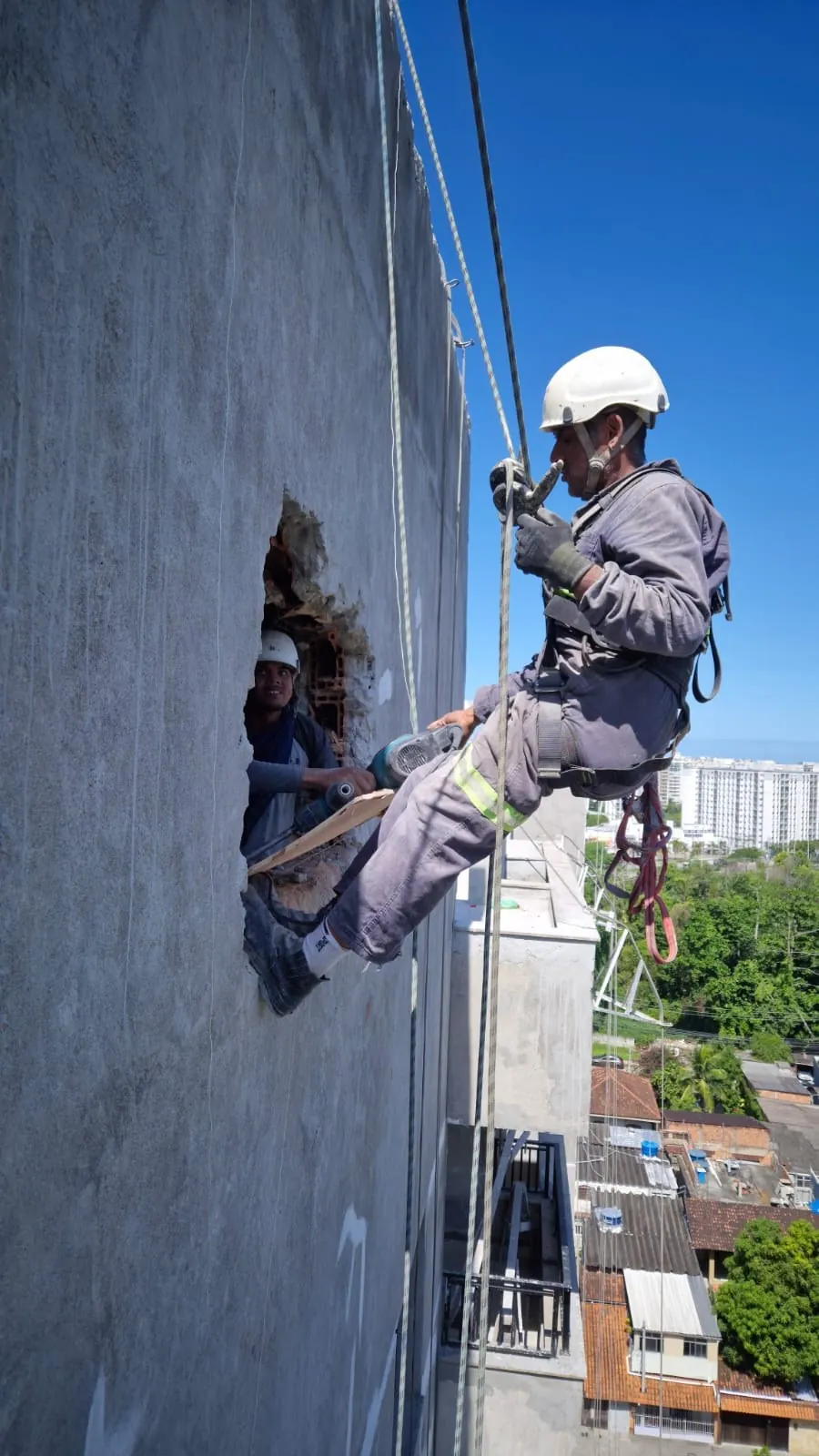 JFS worker performing rope-access maintenance on a building facade